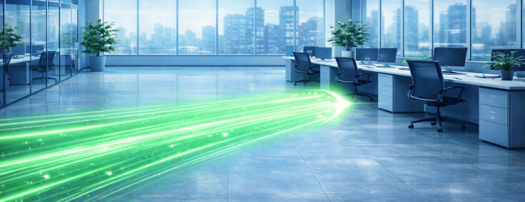 Glowing green light streams flow across a modern office floor with desks, chairs, and floor-to-ceiling city-view windows.